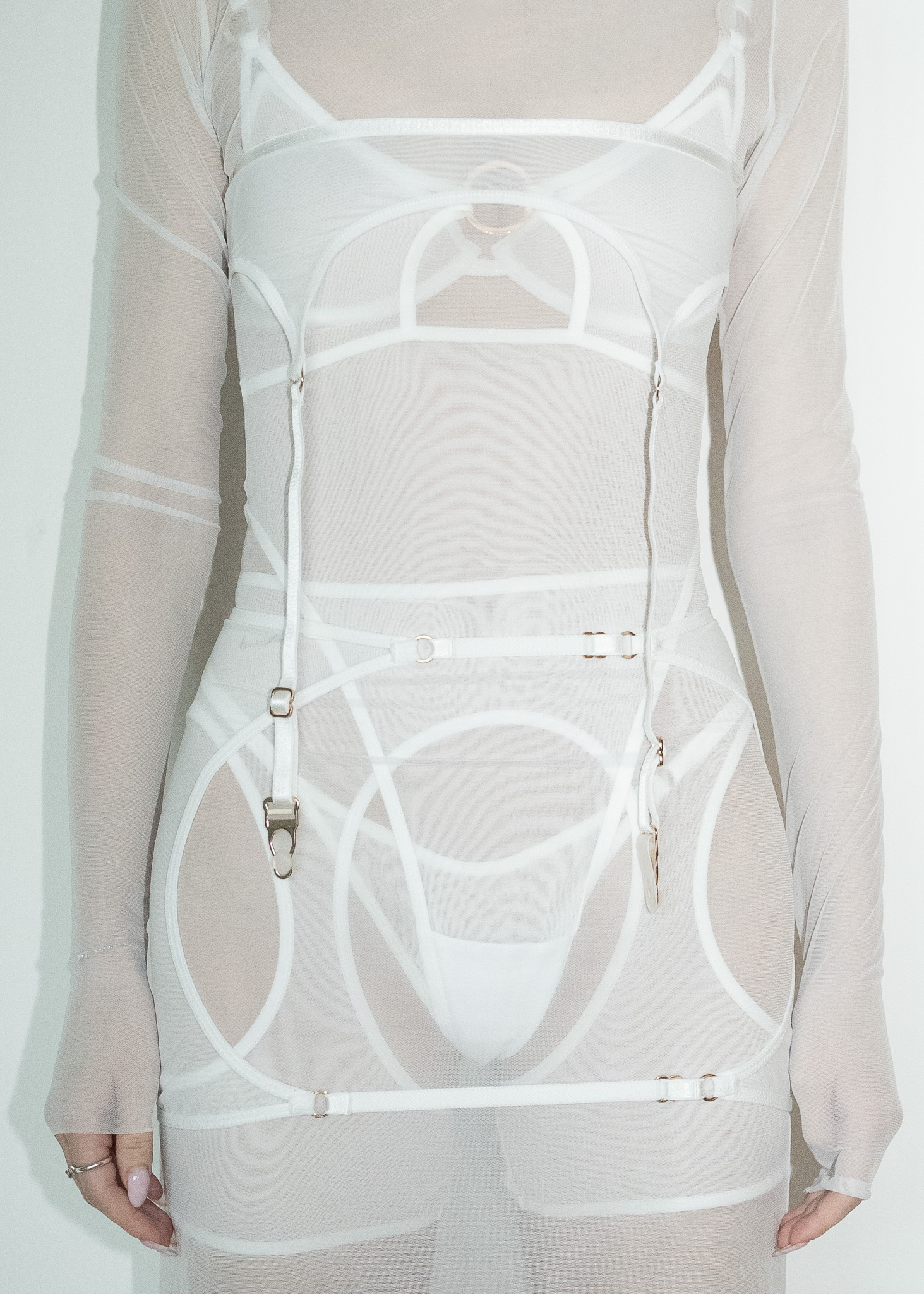 Fashion detail shot of a white sheer top with harness